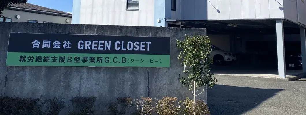 建物の前の塀に取り付けられた看板。「合同会社 GREEN CLOSET」「就労継続支援B型事業所 G.C.B（ジーシービー）」と書かれている